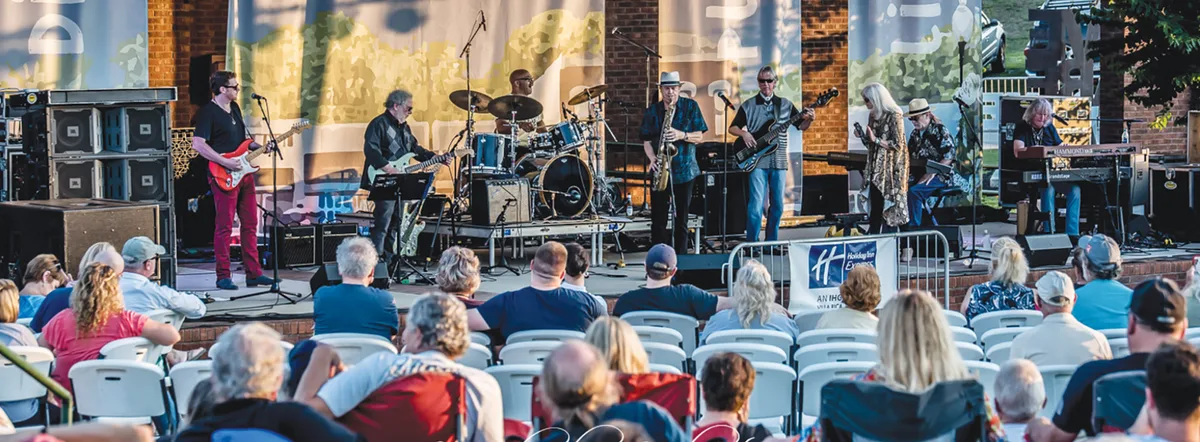 A band performs for a seated outdoor audience at The MILL in Villa Rica.