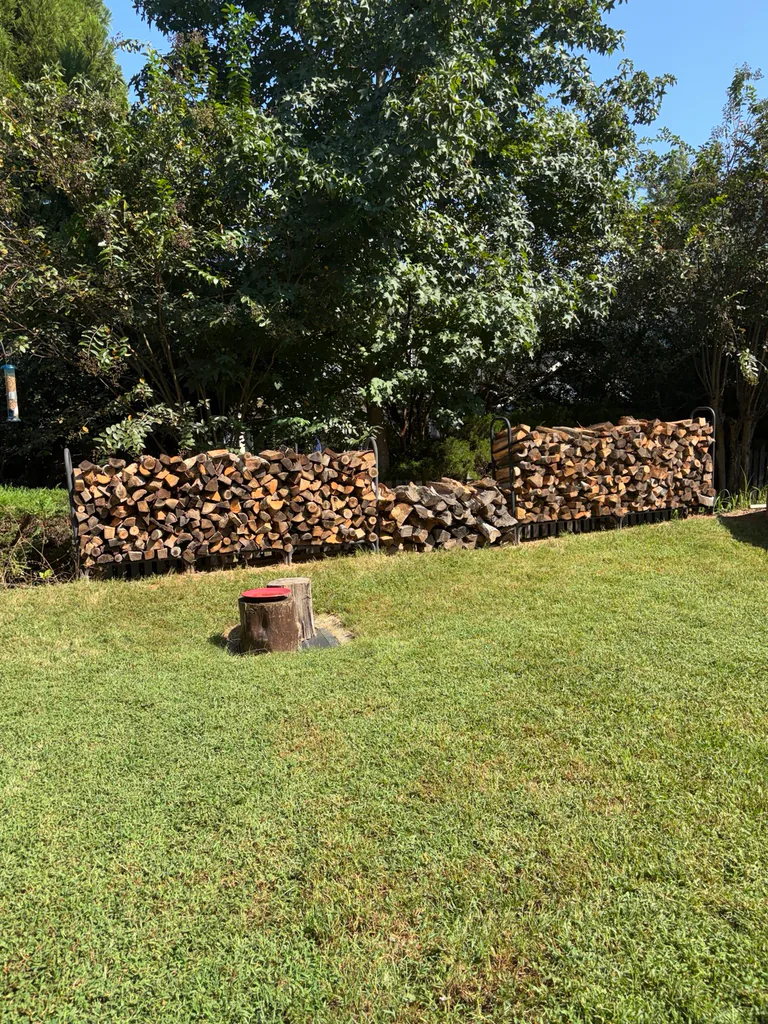 Split firewood delivered and stacked in outdoor racks by Moss and Sons