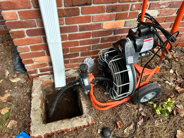 Moss & Sons clearing an outdoor drain with an auger