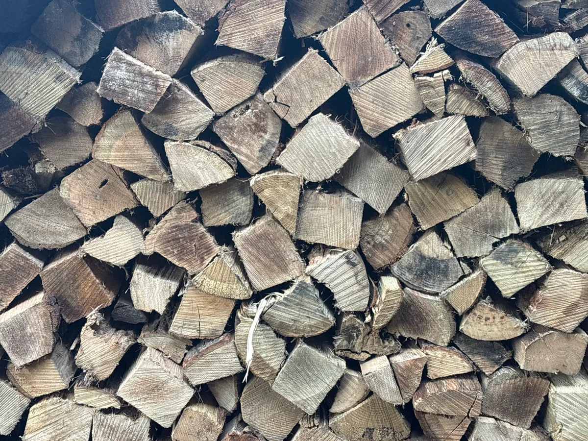 Close-up of stacked split firewood showing the range of piece sizes