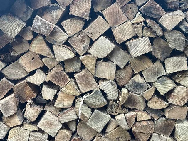 Split firewood stacked by Moss & Sons